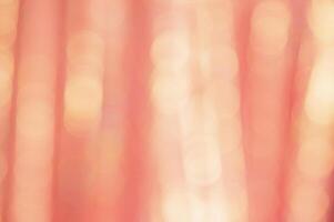 Defocused peach glitter background with sparkles. Defocus light is yellow and orange. photo