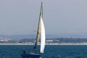 a yacht with a tall sail in the open sea photo