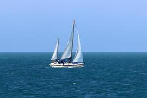a yacht with a tall sail in the open sea photo