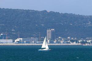 a yacht with a tall sail in the open sea photo