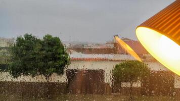 Rainy window view with warm interior lamp reflection in foreground photo