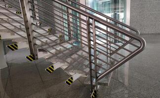 Detail view of a modern stair railing with safety markings in a corporate building photo