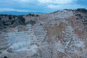 Open-air mining activity in a white marble mine. photo