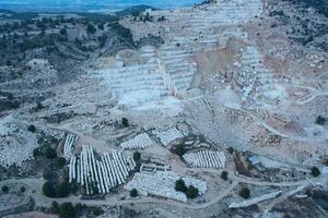 Aerial view of Open-air mining activity in a white marble mine. photo