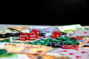 A close-up shot of a table with red dice, poker chips, and Euro banknotes scattered across the surface photo