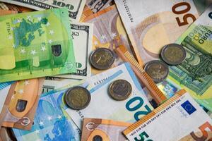 A close-up view of Euro and US dollar banknotes and coins scattered on a flat surface photo