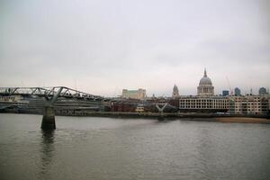 A bridge over a river with a city in the background photo