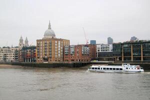 A boat is traveling down a river in front of a building photo