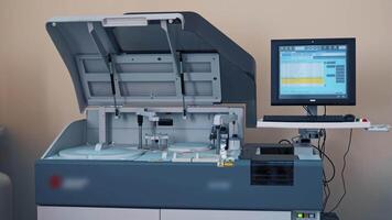 Automated machine at work and the computer screen in the laboratory room. Analysis blood at hospital laboratory. Blood samples in a robotic machine with 3D display. video