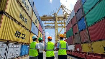 Three men in hard hats standing next to a container ship video