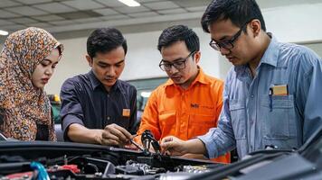 Three people working on a car in a workshop video