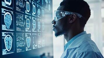 A man in a lab coat looking at a computer screen video