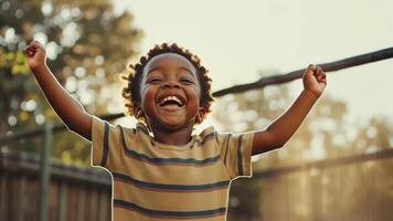 A young boy is smiling and standing on a fence video