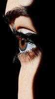 Close up of eye in dramatic lighting with sharp shadows and details. photo