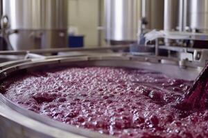 Bubbling fermentation process in a winery with stainless steel vats and flowing red wine photo