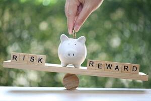 Wording risk and Reward on wood block on natural green background, Business investment and Risk management concept.Financial risk assessment photo