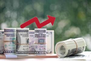 Financial, Red arrow graph and banknotes on natural green background, Business investment and Risk management concept photo