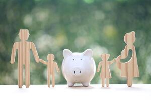 Model family with piggy bank and stack of coins money on natural green background,Save money for prepare in future and family finance concept photo