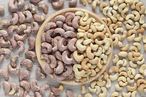 Roasted salted cashew nuts in a bowl on wooder background, Healthy eating concept photo