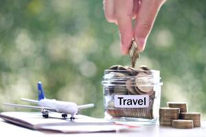 Stack of coins money in the glass bottle and airplane on passport with natural green background,Saving planning for Travel budget of holiday concept photo
