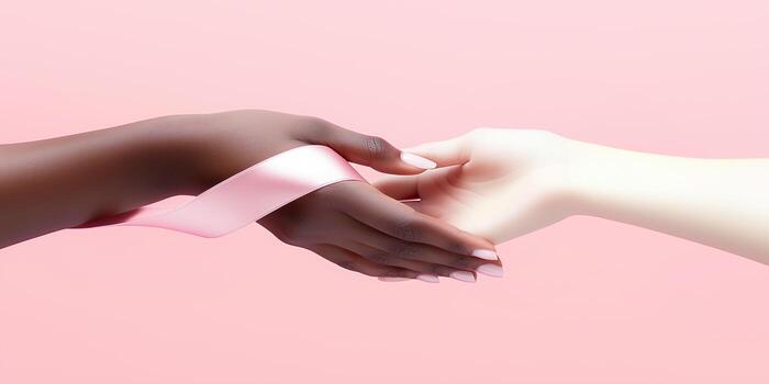 dos manos de diferente piel tonos son suavemente alcanzando para cada otro entrelazados con un rosado cinta foto