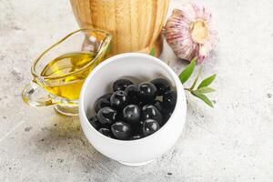 Black olives with oil and branch photo