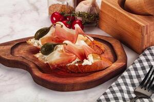 Bruschetta with jamon and caper berries photo