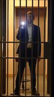 A mysterious figure in jail uses a flashlight, enhancing the intrigue and depth of the scene video
