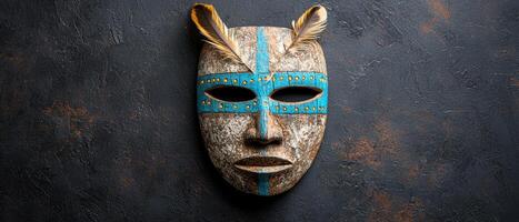 Tribal mask with feathers on dark background photo