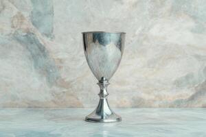 Elegant silver trophy cup on marble background photo