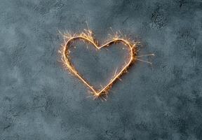 Sparkling heart shaped light on dark background photo