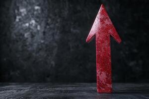 Dramatic red arrow pointing upwards on dark background photo