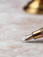 Close up of a gold fountain pen nib on a wooden surface photo