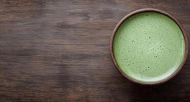 Matcha green tea latte in wooden bowl on rustic table photo