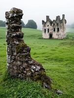 Mysterious medieval castle ruins in a lush green field photo
