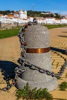 Stub posts linked in a chain on a quay photo