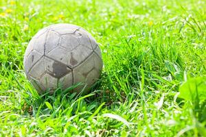 Old soccer ball on the green grass photo