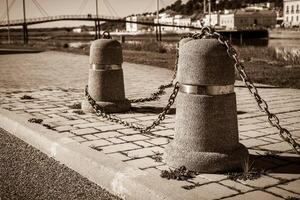 Stub posts linked in a chain on a quay photo