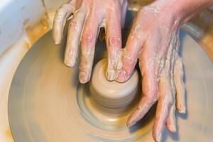 womens hands of a potter creating an earthen jar photo