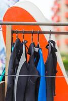 Diving suits and surf boards in a store photo