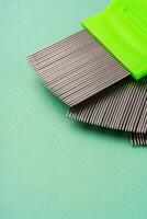 Three combs for lice removing on green background photo