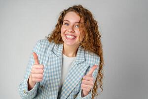 Young Woman Giving Ok Sign on gray background photo