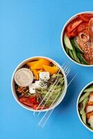 Different poke bowls on blue background top view photo