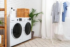 Modern Laundry Room With White Washing Machines and Colorful Clothes photo