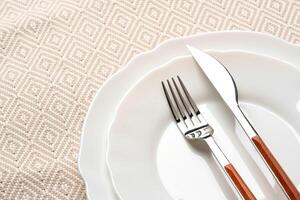 Empty plate with fork and knife on table photo