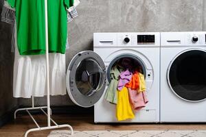 Open Front Loading Washing Machine With Colorful Clothes photo