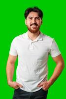 A smiling young man with a beard poses against a bright green background photo