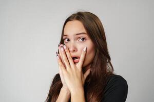 Young Woman Covering Her Face With Hands While Looking Scared photo