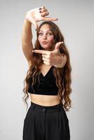 Young Woman Making Frame With Hands and Smiling at Camera photo
