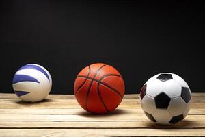 Set of various sport balls on wooden floor on black background photo